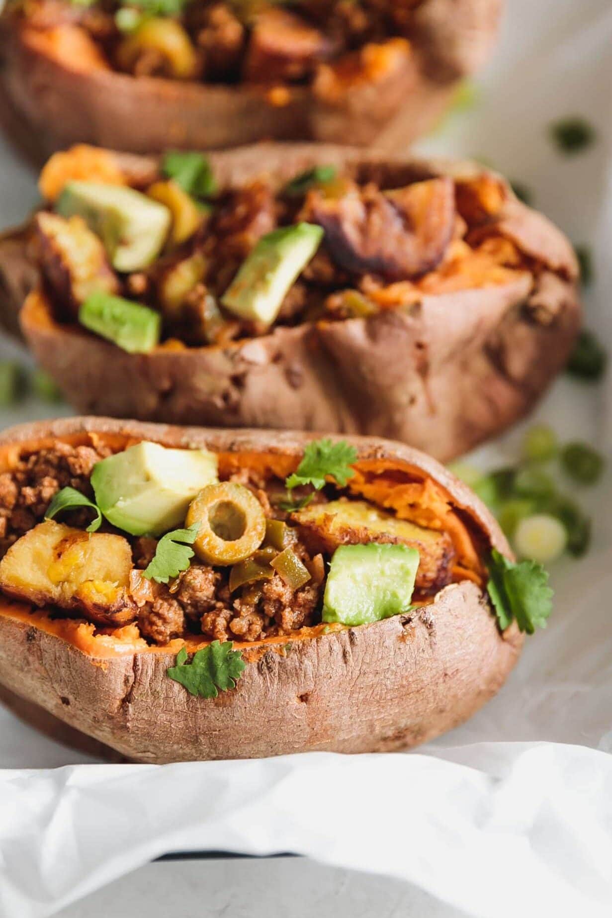 Sweet potatoes stuffed with Cuban-style lean ground beef, chopped sweet plantains, and avocado. A flavorful, easy-to-make 35-minute meal for busy weeknights!