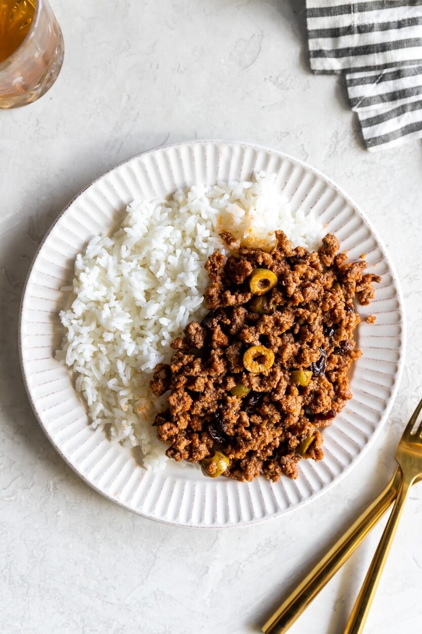 cuban picadillo served with white rice on a white plate