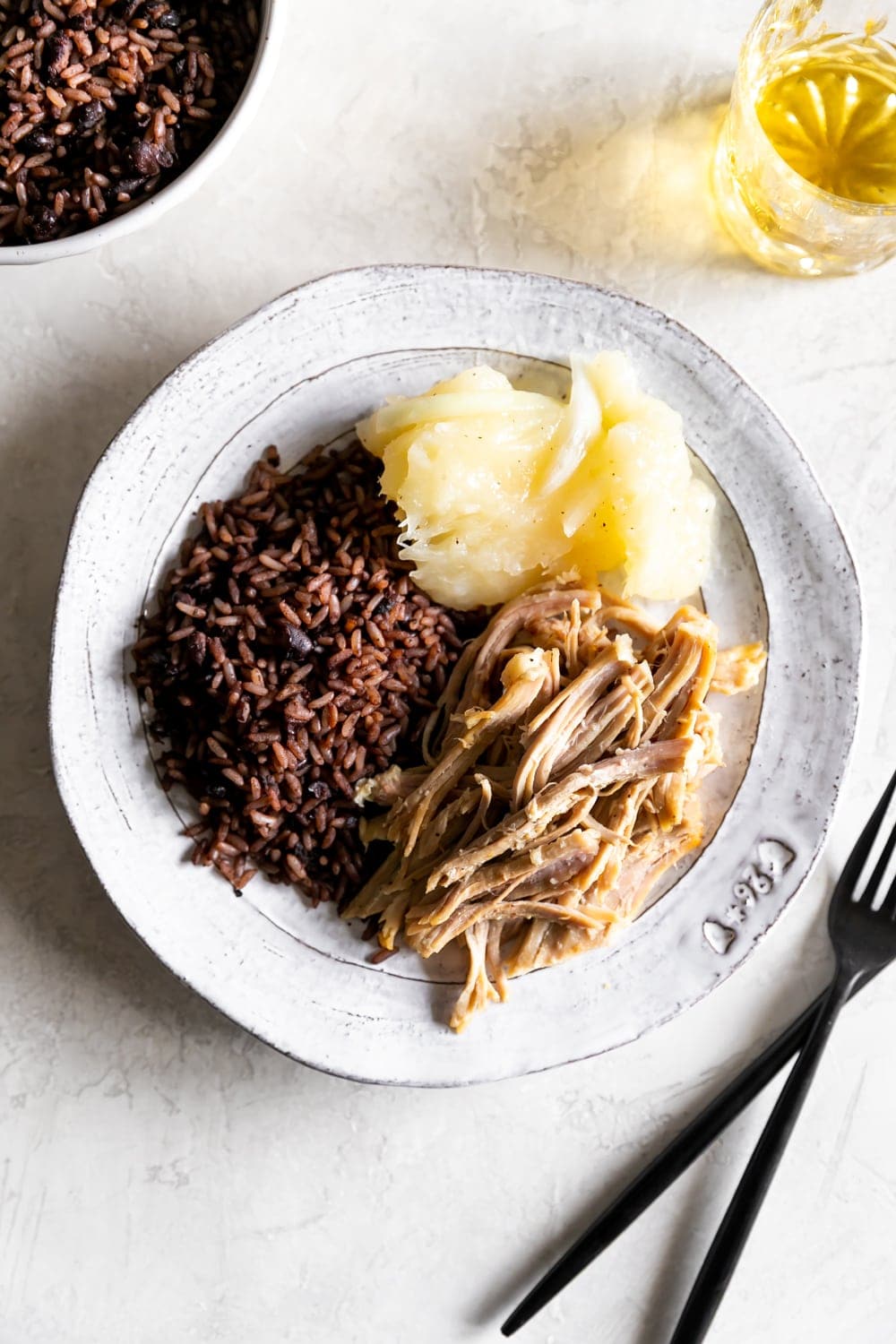 cuban roast pork, cuban black beans and rice, yuca with mojo on a plate