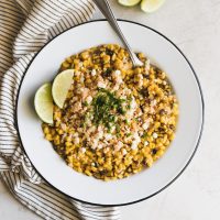 Easy Chipotle Mexican Street Corn. Fire roasted corn mixed with spicy chipotle mayo and mozzarella then topped with crushed pork rinds, crumbled cotija and chives.