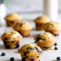 easy blueberry muffins on table with blueberries all around