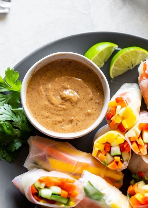 a plate with fresh spring rolls and vegan peanut sauce in a bowl