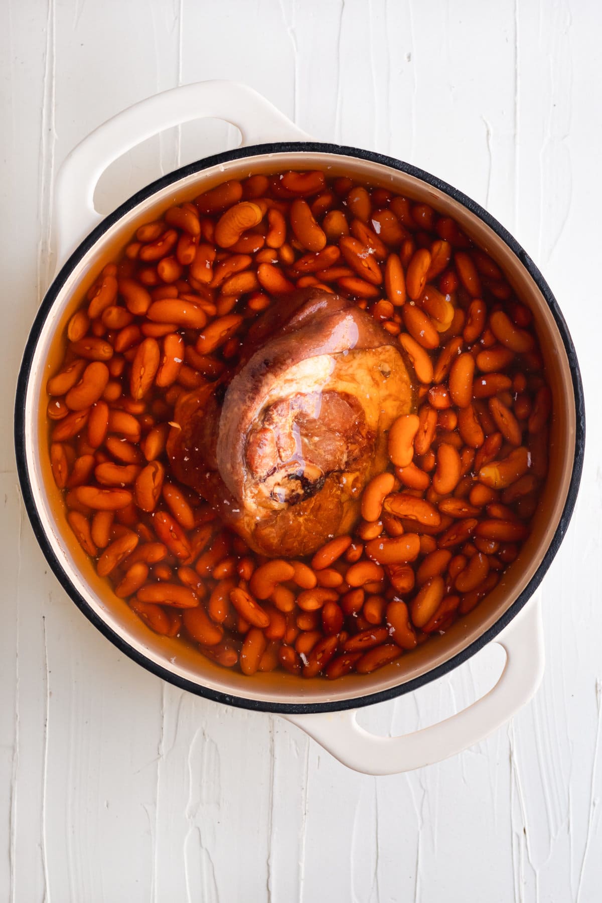 ham hock soaking with red beans in a Dutch oven