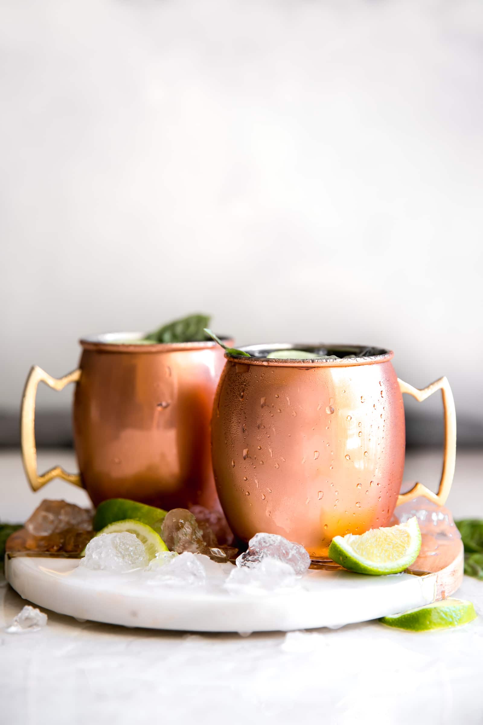 Guava Basil Moscow Mule. A twist to the traditional refreshing Vodka cocktail made with spicy ginger beer, guava nectar, fresh lime and sweet basil. Delicious drink for any time of year!