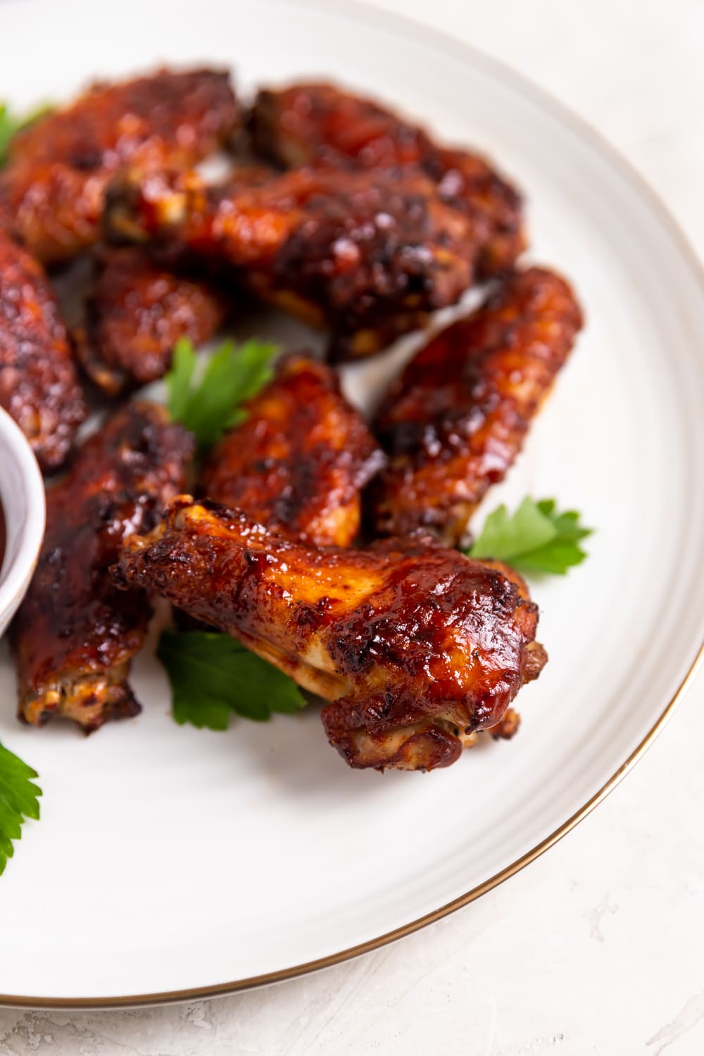 guava bbq chicken wings on a white place with chopped parsley