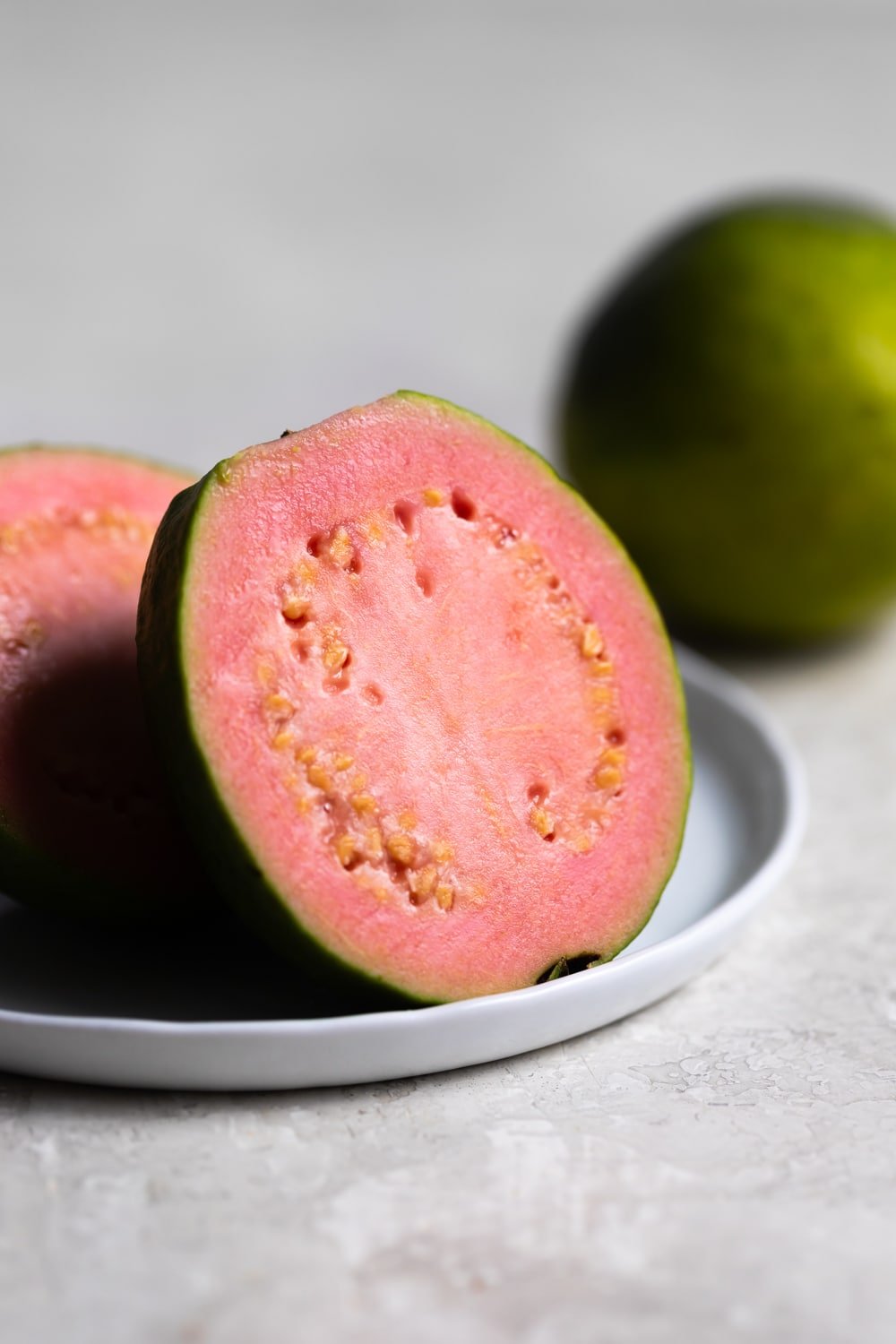 pink guava on a white place sliced open 