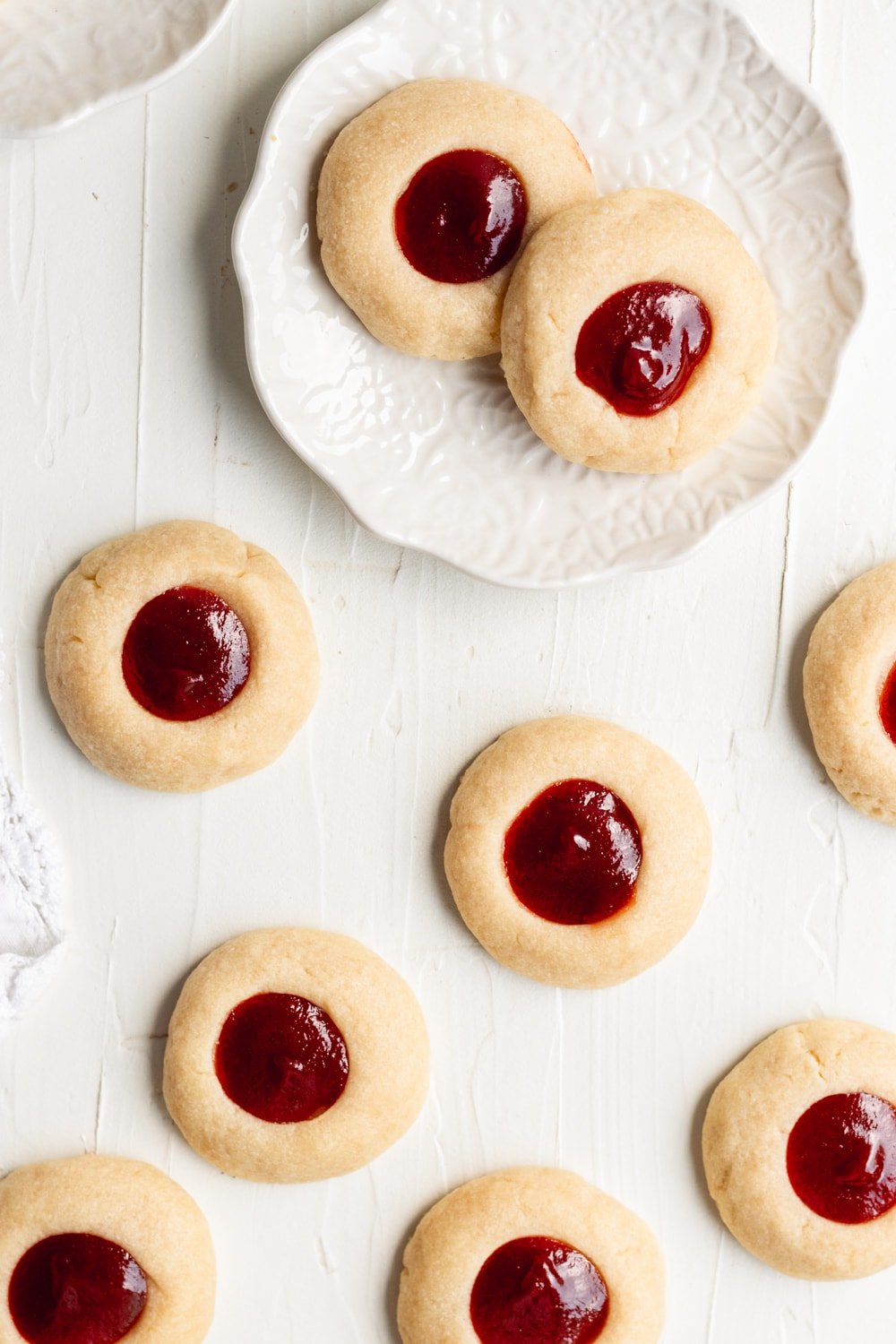 overhead shot of guava jam thumbprint cookies on a white table