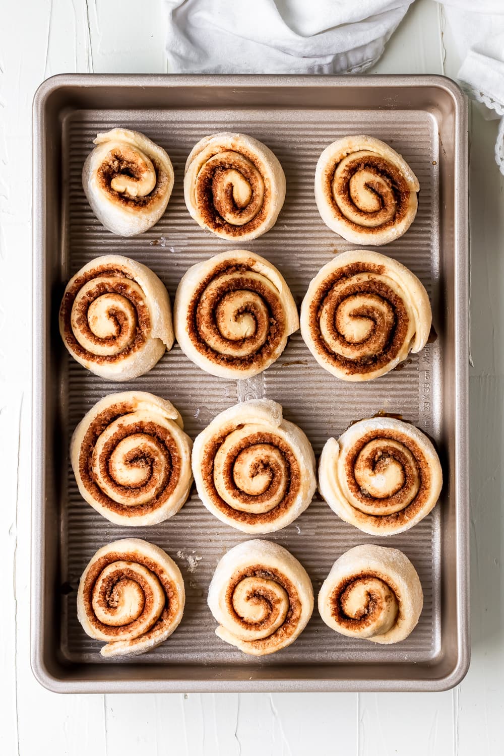 rolled up cinnamon rolls before baking on a baking dish