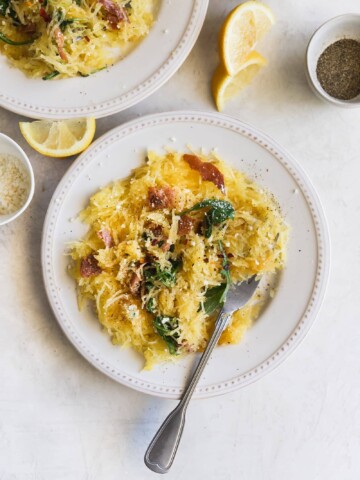 Lemony Cacio e Pepe Spaghetti Squash. A flavorful, low carb meal made with roasted spaghetti squash, lemon, arugula, pancetta, red pepper flakes, grated Parm and fresh pepper. Healthy weeknight dinner!