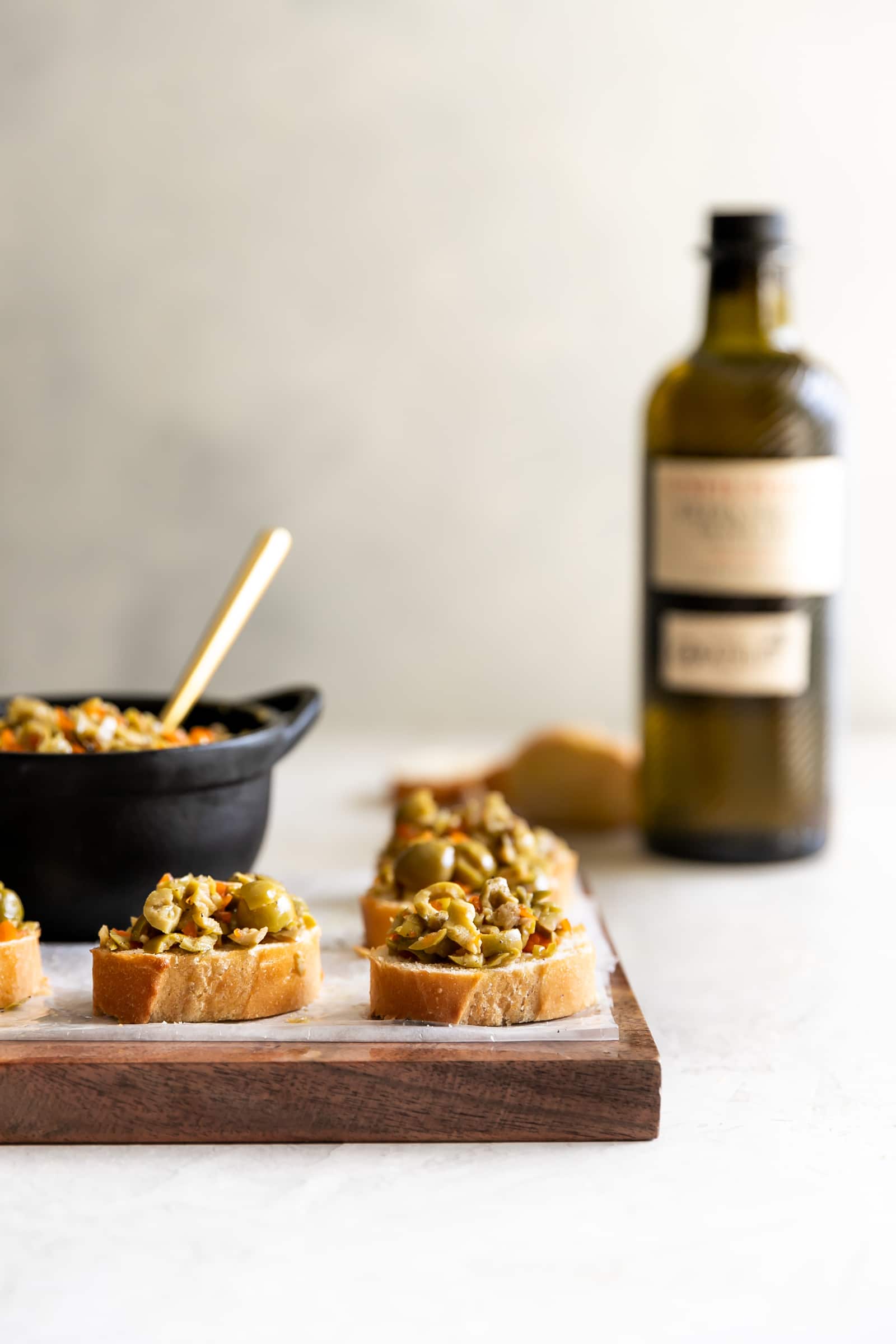 A simple yet irresistible appetizer made with tart, briny olives, capers, fresh garlic, pepper, and olive oil then served on toasted baguette slices brushed with olive oil.