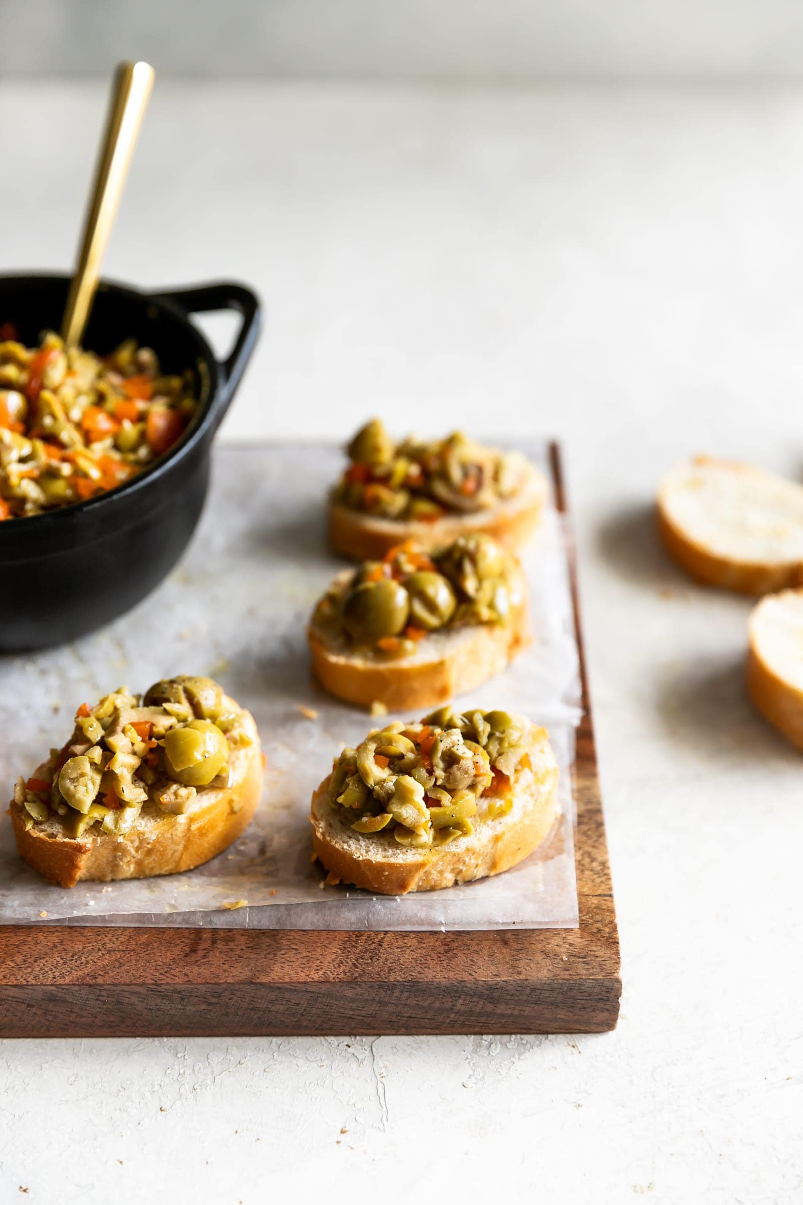 A simple yet irresistible appetizer made with tart, briny olives, capers, fresh garlic, pepper, and olive oil then served on toasted baguette slices brushed with olive oil.