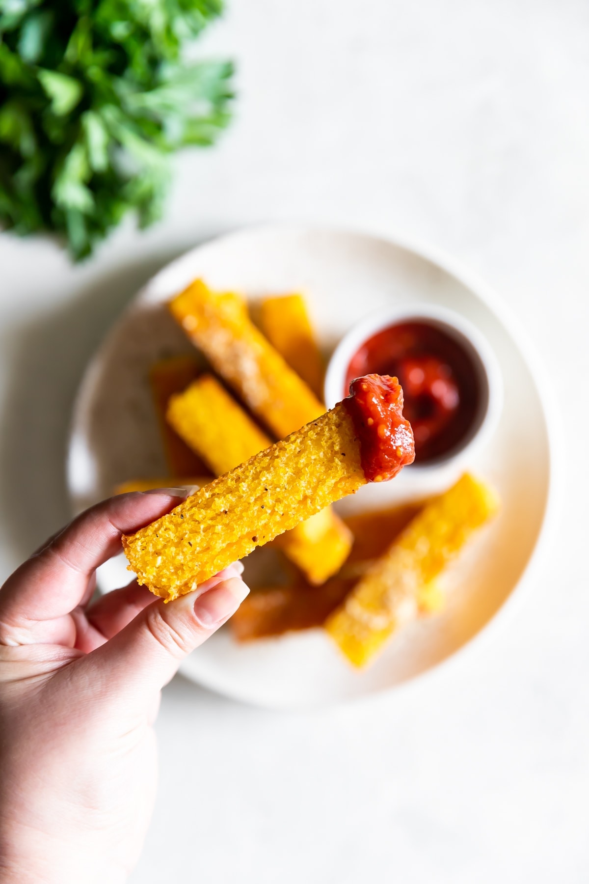 one polenta fry with spicy ketchup dipped on it