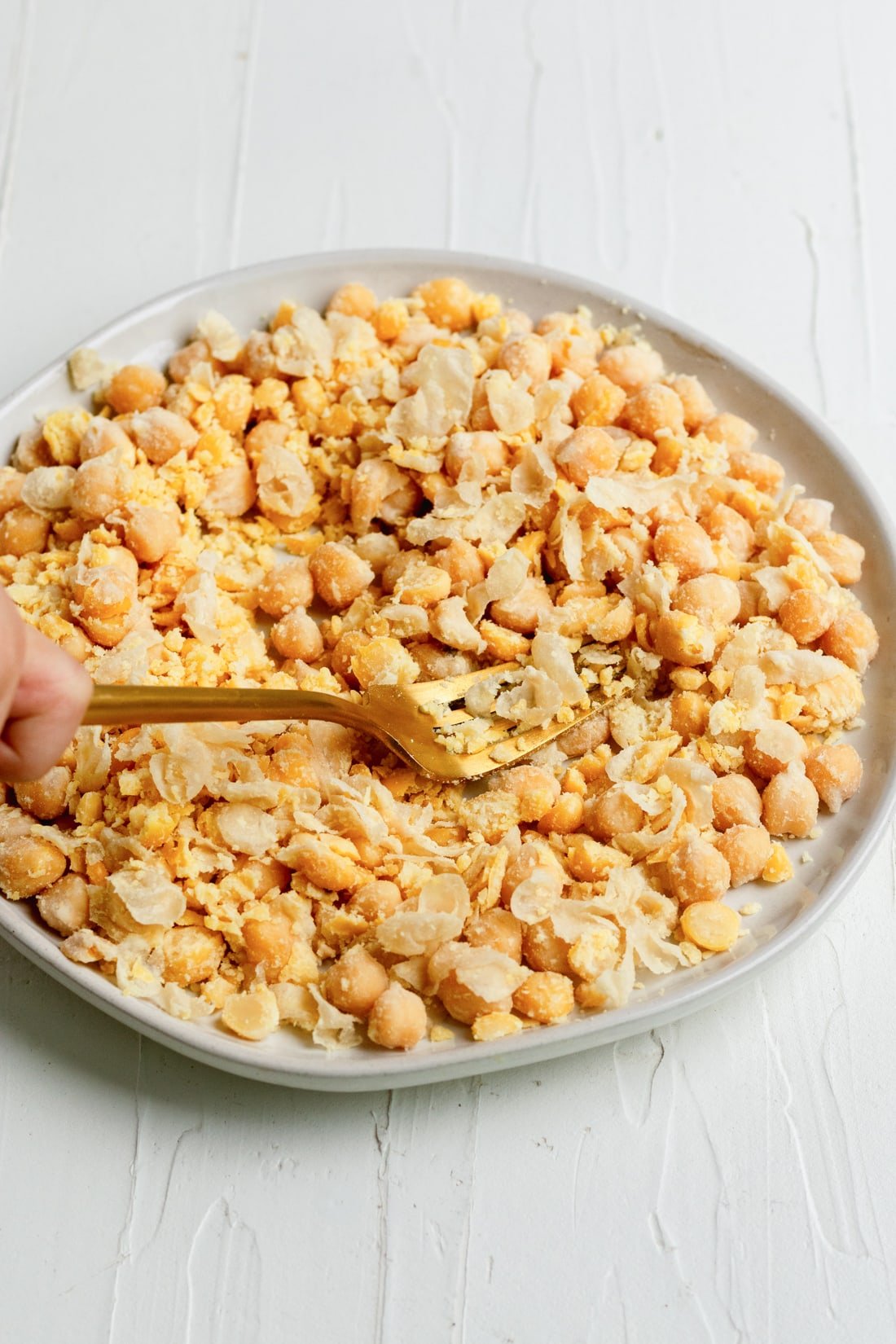 mashing softened chickpeas on a plate