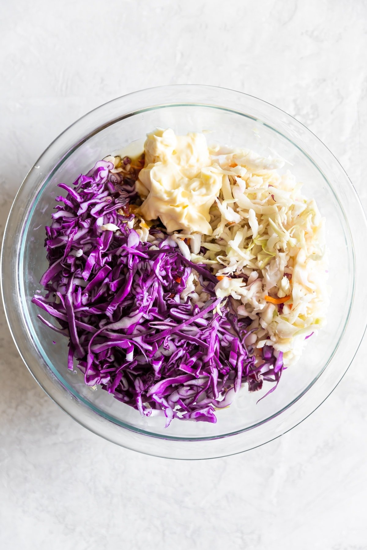 slaw with shredded red cabbage, mayo, honey, red wine vinegar, and coleslaw in a bowl before mixing
