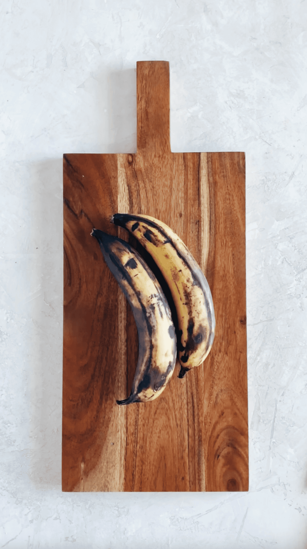 yellow and black ripe plantains on a wooden block