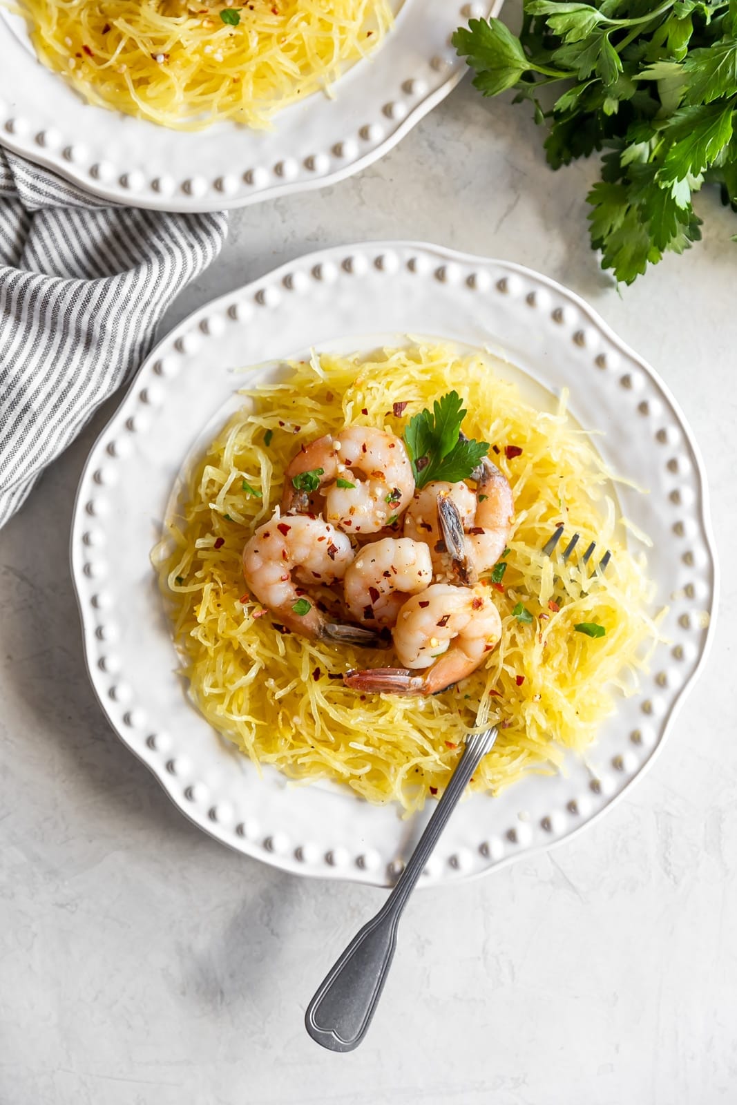 Sautéed shrimp tossed in a quick + easy garlic, red pepper flakes, parsley, white wine, and butter sauce served on top of spaghetti squash.