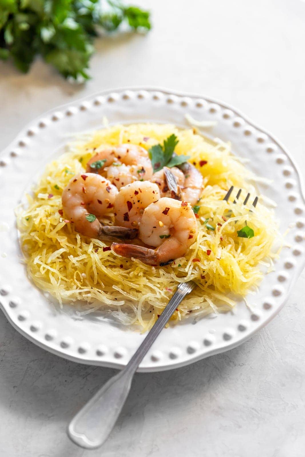 Sautéed shrimp tossed in a quick + easy garlic, red pepper flakes, parsley, white wine, and butter sauce served on top of spaghetti squash.