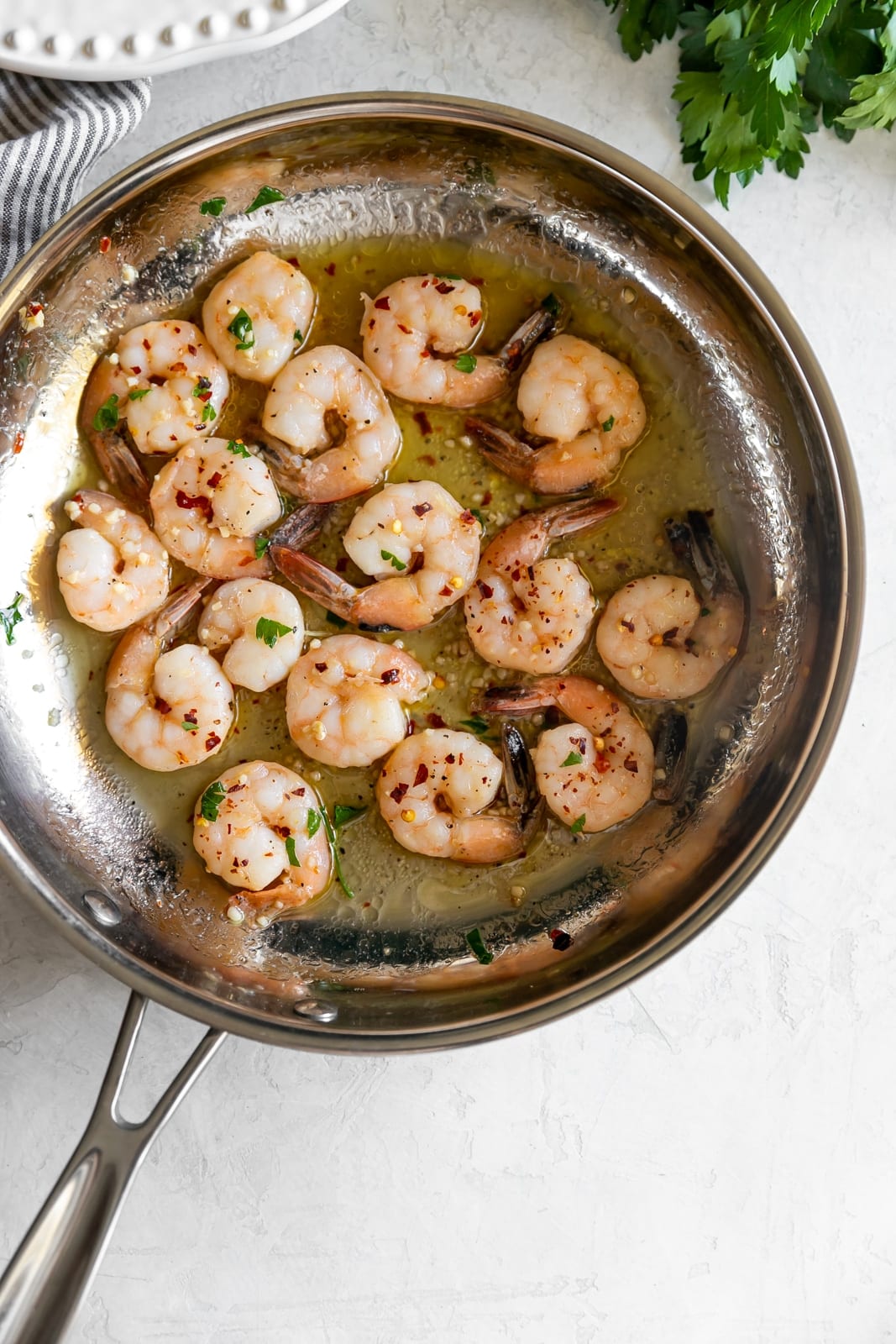 Sautéed shrimp tossed in a quick + easy garlic, red pepper flakes, parsley, white wine, and butter sauce served on top of spaghetti squash.