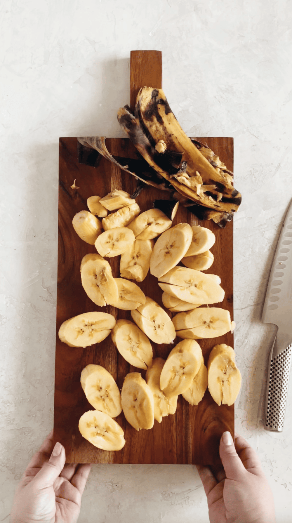 sliced ripe plantains on a wooden block ready for frying