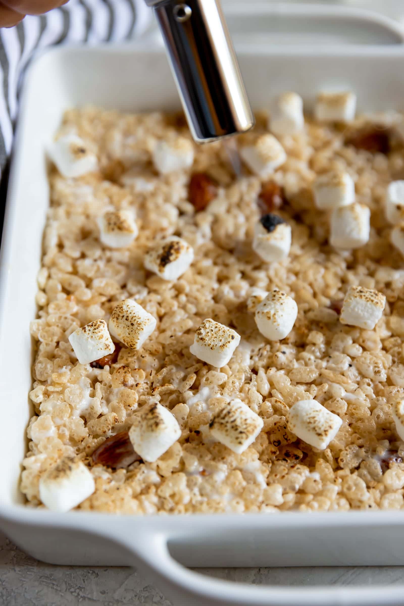 A sweet crispy classic treat with a smoky twist! Rice cereal, torched marshmallows, and smoked almonds come together to make Smoky Rice Krispie Treats.