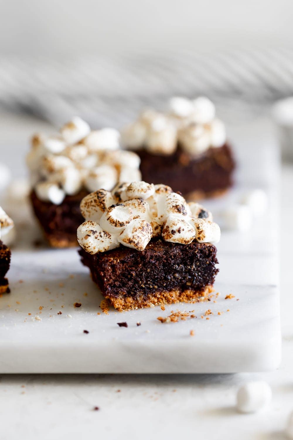 smores brownies on a marble slab with toasted marshmallows