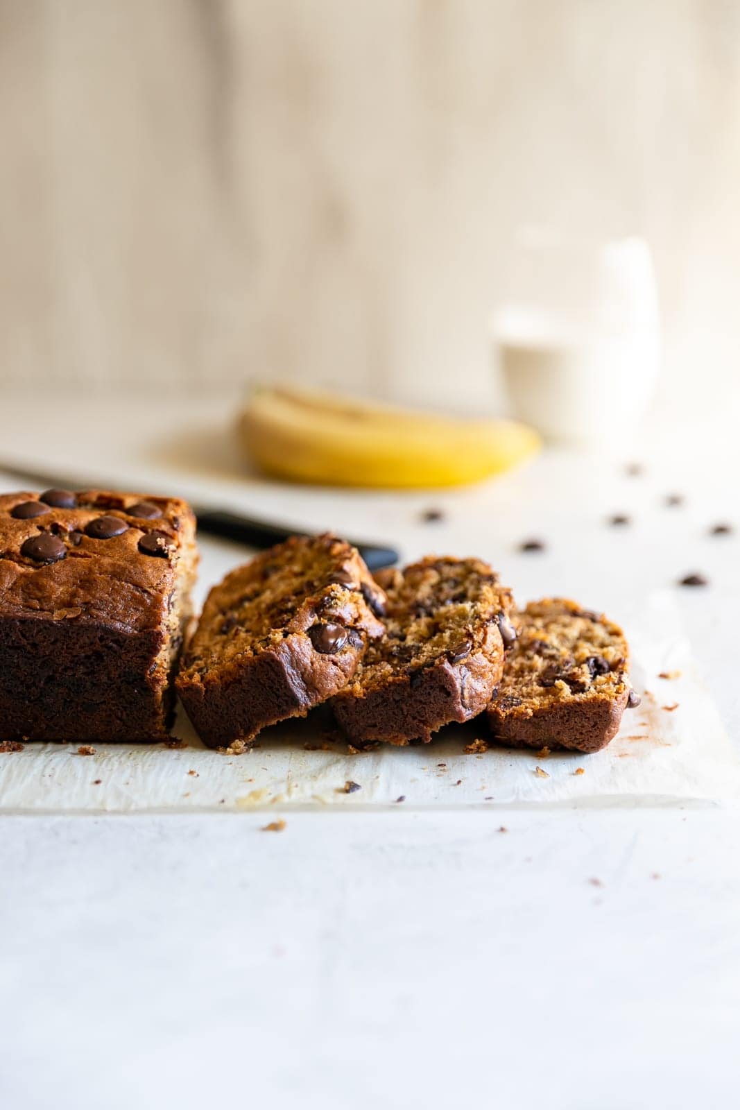 sliced moist chocolate chip banana bread on a white surface