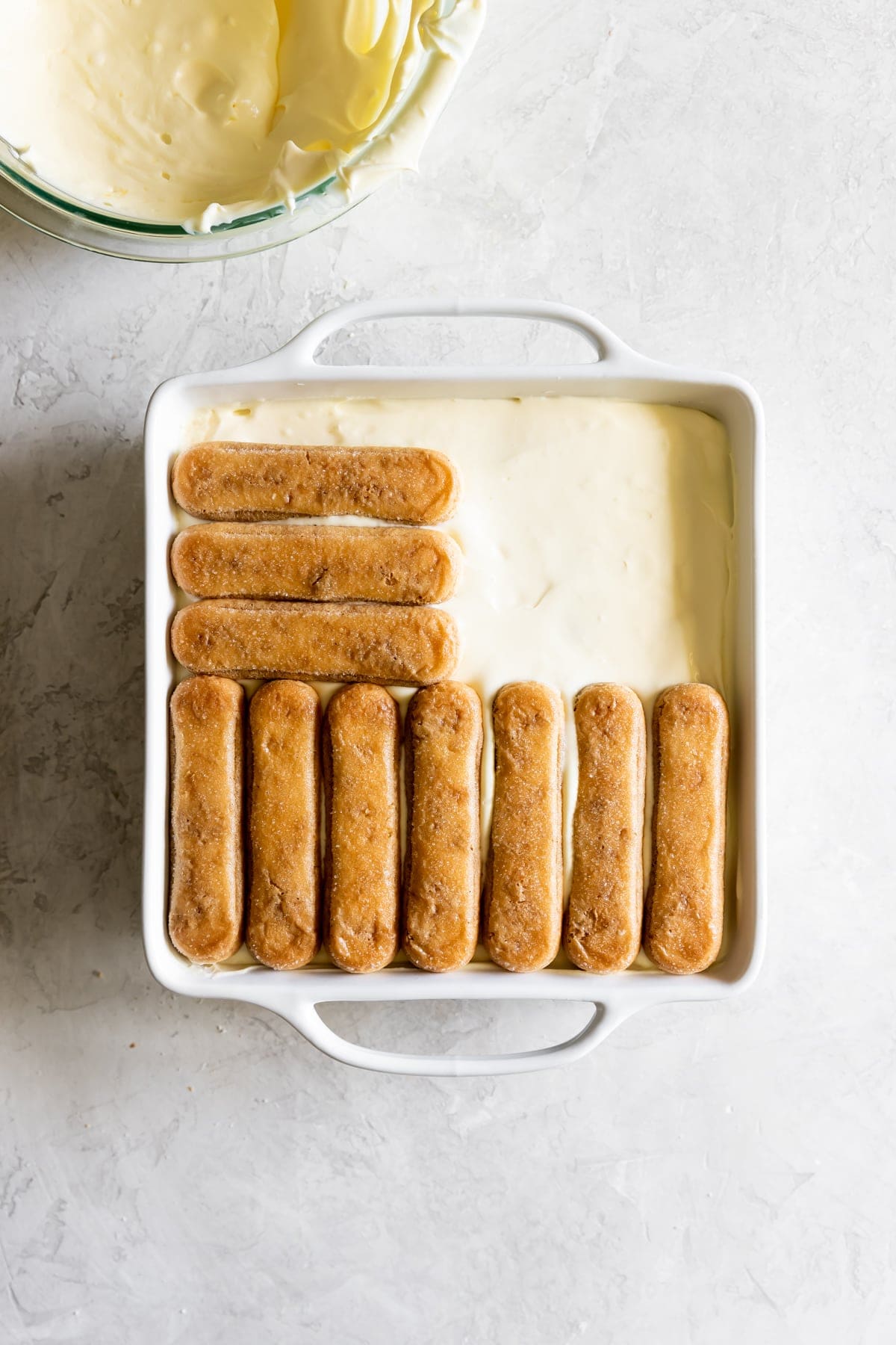 layers of mascarpone filling and espresso-soaked ladyfingers in a baking dish