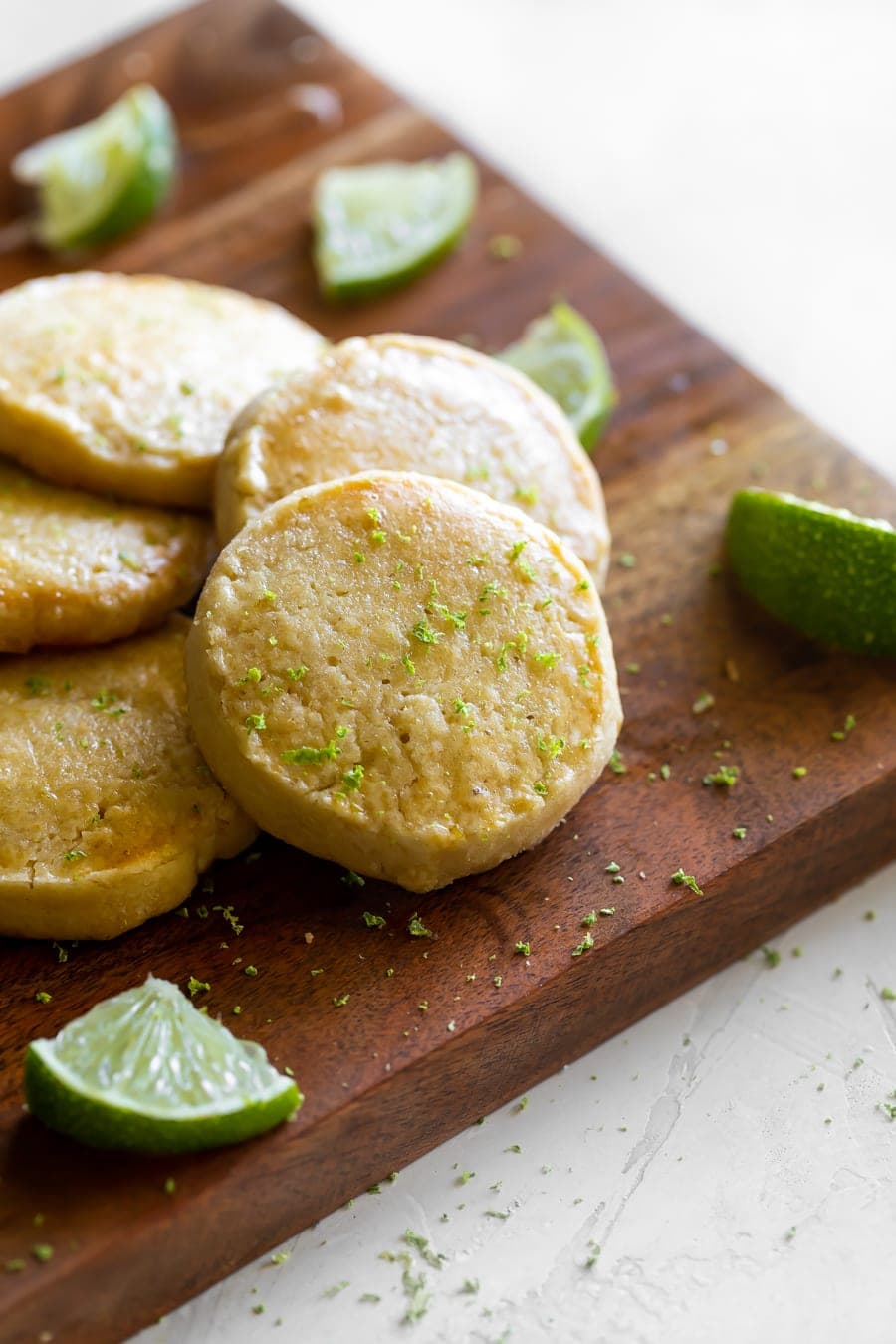 einfache Shortbread-Kekse auf einem Schneidebrett mit Limettenschale oben